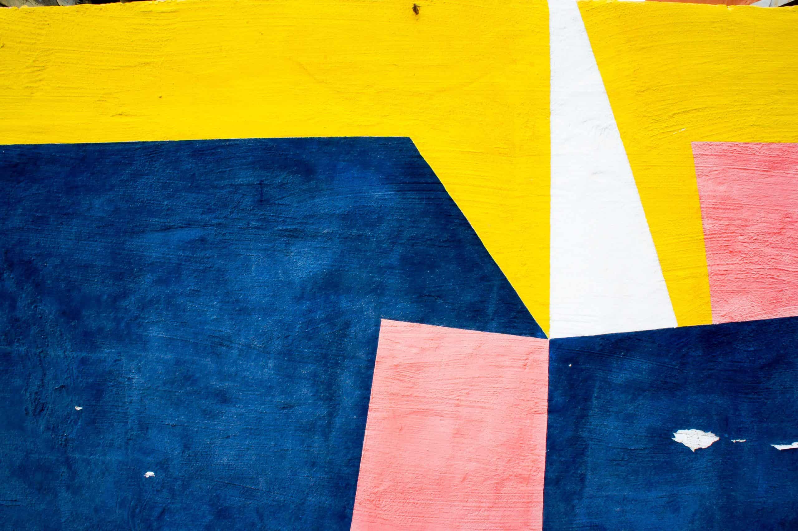An abstract painting of yellow, blue, and pink shapes